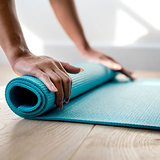 person rolling yoga mat